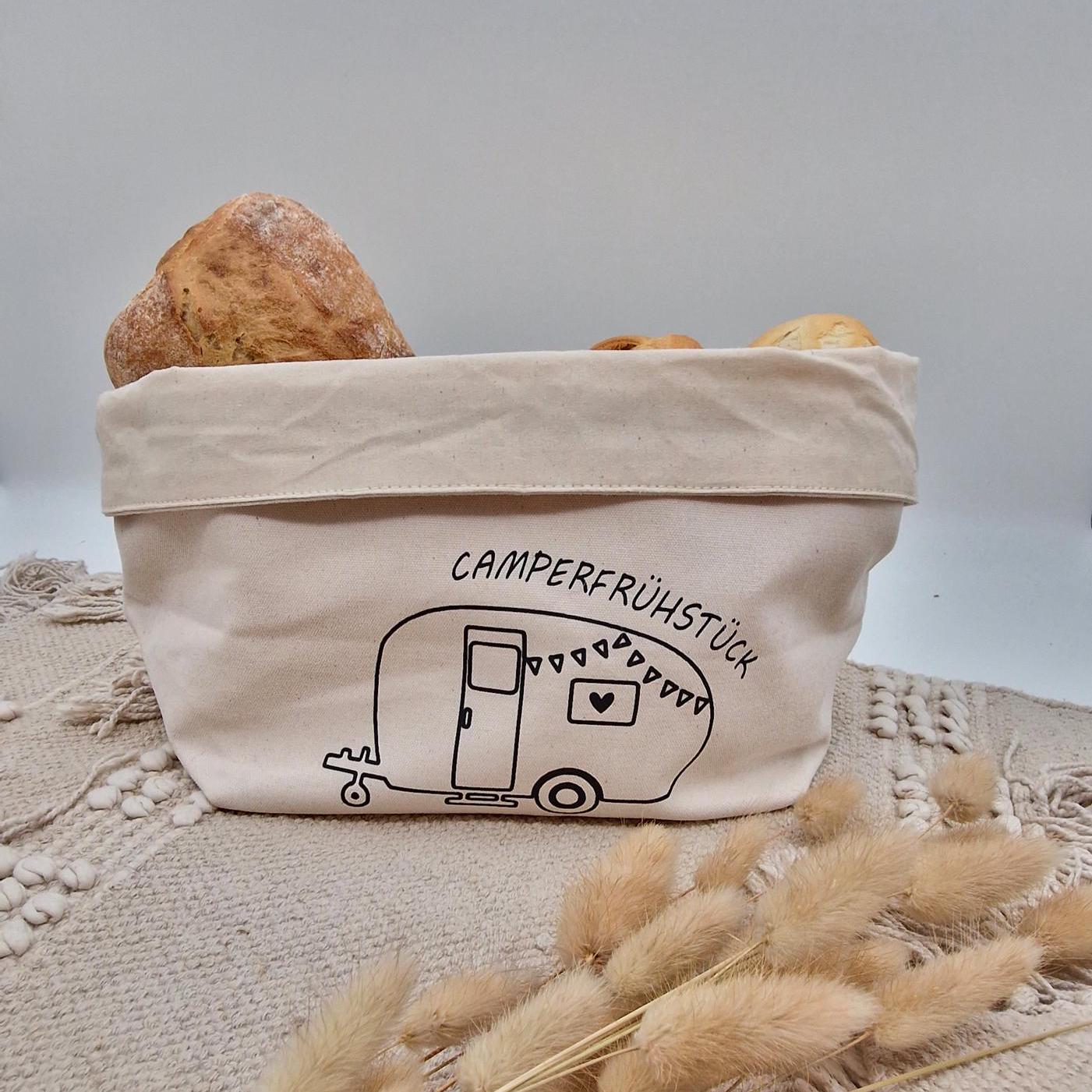 Schöner Naturfarbener Brotkorb aus Baumwollstoff, mit Aufgedrucktem Campingwagen und der Aufschrift Camper frühstück. der Druck kann leicht erfühlt werden, und ist einseitig. Die Obere Kante kann ja nach Inhalt umgeklappt werden. Er kann einfach zusammengefaltet und verstaut werden. Die Größe ist vergleichbar mit einem Mittleren Kochtopf.